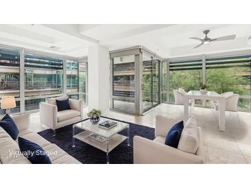 Bright living room boasts a statement wall of windows, modern furnishings, and ample space at 7131 E Rancho Vista Dr # 3001, Scottsdale, AZ 85251