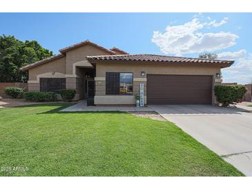 Charming single-story home featuring a well-manicured lawn and a two-car garage at 17806 N 54Th Ln, Glendale, AZ 85308