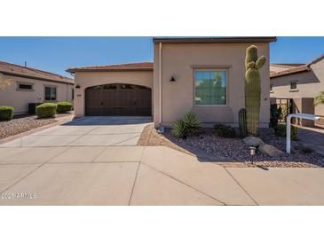 Charming single-story home with a two-car garage, desert landscaping and brown accents at 35756 N Clementine Trl, San Tan Valley, AZ 85140