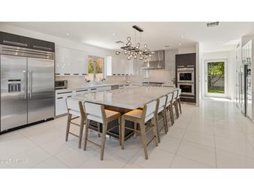 Bright and modern kitchen featuring a large center island, stainless appliances, and sleek cabinetry at 523 W Vista Ave, Phoenix, AZ 85021