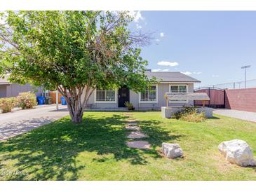 Charming single-story home featuring a well-maintained lawn and stone pathway leading to the front door at 7235 W Flower St, Phoenix, AZ 85033