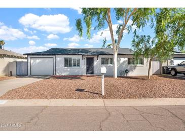 Charming single-story home with well-maintained landscaping and a classic design under a partly cloudy sky at 830 E Orchid Ln, Phoenix, AZ 85020