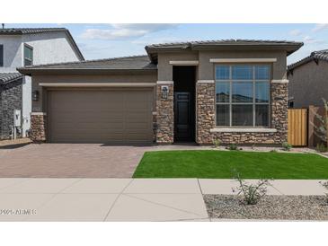 Beautiful single-Gathering home with a two-car garage, stone accents, green grass and a paver driveway at 22762 E Stacey Rd, Queen Creek, AZ 85142