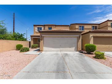 Tan two-story home with a two-car garage and desert landscaping at 2565 E Southern Ave # 130, Mesa, AZ 85204
