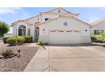 Charming single-story home featuring a two-car garage, lush landscaping, and a welcoming entrance, and a driveway at 2821 E Pontiac Dr, Phoenix, AZ 85050