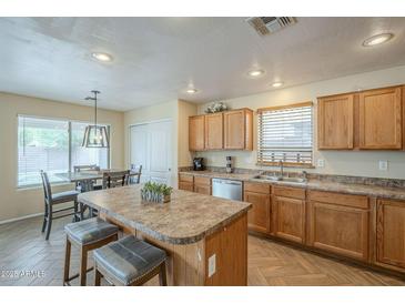 Spacious kitchen with an island, bar stools, and stainless steel appliances at 69 W Grey Stone St, San Tan Valley, AZ 85143