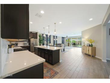 Open floor plan features large kitchen island, hardwood floors and easy access to living and dining areas at 8419 S 164Th Dr, Goodyear, AZ 85338