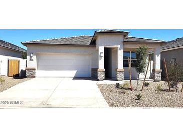 Charming single-story home featuring a two-car garage and desert landscaping for a modern look at 10612 W Sonrisas St, Tolleson, AZ 85353