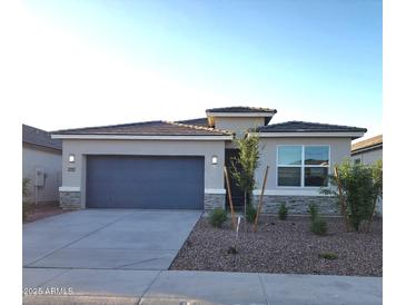 Charming single-story home with a two-car garage, stone accents, and low-maintenance desert landscaping at 10620 W Sonrisas St, Tolleson, AZ 85353