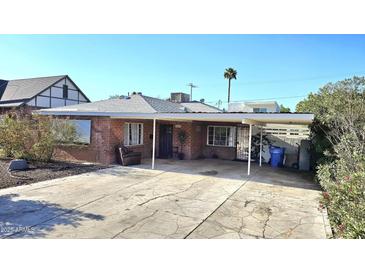Charming single-story brick home featuring a covered carport and a well-maintained front yard at 1520 W Encanto Blvd, Phoenix, AZ 85007