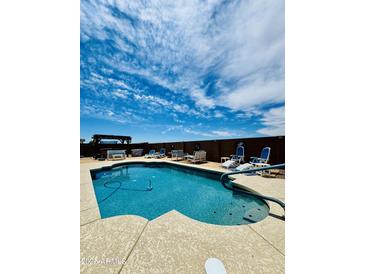 Enjoy this backyard pool with lounge chairs and a covered patio at 17840 N Smith Dr, Maricopa, AZ 85139