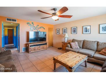 Comfortable living room with a ceiling fan, tile flooring, and a large entertainment center for modern living at 2534 N Mitchell St. St, Phoenix, AZ 85006
