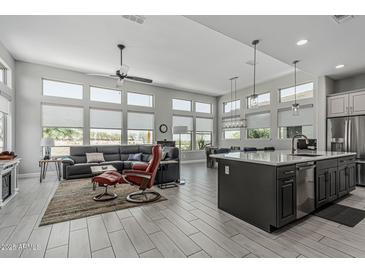 Spacious living room featuring oversized windows, tile floors, and stylish furniture at 5233 N 207Th Dr, Buckeye, AZ 85396