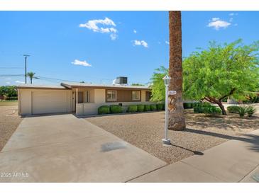 Charming single-story home boasts a well-maintained front yard with mature landscaping and a two-car garage at 10429 W Oakmont Dr, Sun City, AZ 85351
