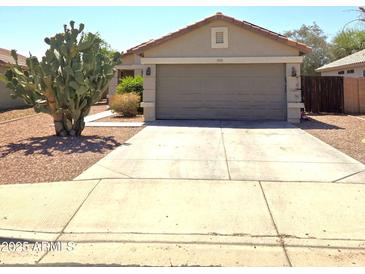 Charming single-story home featuring a two-car garage and desert landscaping at 15023 W Redfield Rd, Surprise, AZ 85379