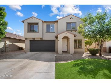 Charming two-story home with a well-manicured lawn and a two-car garage, complete with desert landscaping at 1887 W Desert Seasons Dr, Queen Creek, AZ 85144