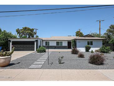 Charming single-story home with a modern design, desert landscaping, and a spacious two-car garage at 3336 E Earll Dr, Phoenix, AZ 85018