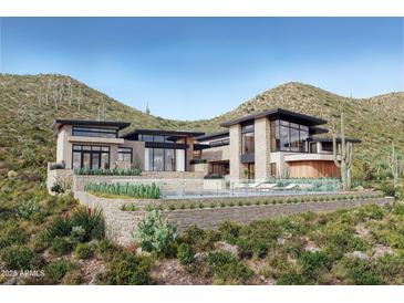 Stunning modern home featuring stone accents, black trim, large windows, and a luxurious pool with desert landscaping at 3367 N Highlands Dr # 39, Buckeye, AZ 85396