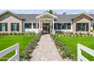 Charming single-story home featuring a stone facade and meticulously landscaped front yard with a brick walkway at 3616 N 54Th Pl, Phoenix, AZ 85018