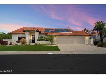 Charming single-story home with a three-car garage, tile roof, solar panels, and well-maintained landscaping at 10510 E Terra Dr, Scottsdale, AZ 85258