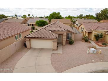 Charming single-Gathering home featuring a tile roof, low-maintenance landscaping, and a two-car garage at 2397 E Winchester Pl, Chandler, AZ 85286