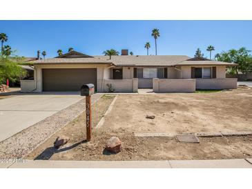 Charming single-story home featuring a two-car garage and desert landscaping, freshly painted exterior at 3045 W Palmaire Ave, Phoenix, AZ 85051