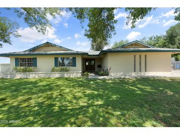 Charming single-story home with green lawn and blue shutters at 944 E Melody Dr, Gilbert, AZ 85234