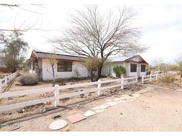 Ranch-style home with solar panels and a rustic white fence in a desert landscape at 36655 N 25Th St, Cave Creek, AZ 85331