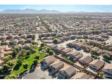 Expansive aerial view of a residential community, showcasing the neighborhood layout and mountain backdrop at 4626 N 111Th Ln, Phoenix, AZ 85037