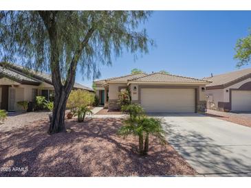 Charming single-story home features a well-maintained landscape, a tiled roof and a two-car garage at 10387 W Runion Dr, Peoria, AZ 85382