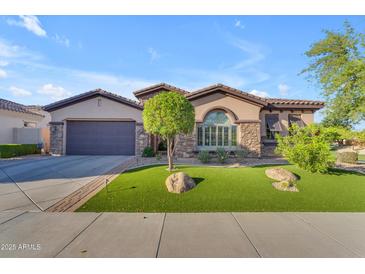 Beautiful single-story home featuring well-manicured front yard and a two-car garage at 15716 W Sheridan St, Goodyear, AZ 85395