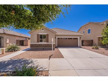 Charming single-story home featuring a two-car garage, desert landscaping, and a welcoming facade on a sunny day at 21277 E Cherrywood Dr, Queen Creek, AZ 85142