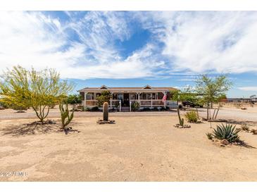 Charming single-story home featuring a cozy front porch and desert landscaping under a beautiful sky at 30517 W Lynwood St, Buckeye, AZ 85396