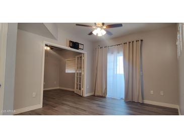 Open living room features wood floors, ceiling fan and leads to office with french doors at 3434 E Baseline Rd # 168, Phoenix, AZ 85042