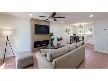Inviting living room features a fireplace, TV, and modern ceiling fan at 5550 N 12Th St # 2, Phoenix, AZ 85014
