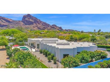 Stunning architectural home with mountain views, pool, and lush landscaping creates a private desert oasis at 6321 N Camelback Manor Dr, Paradise Valley, AZ 85253
