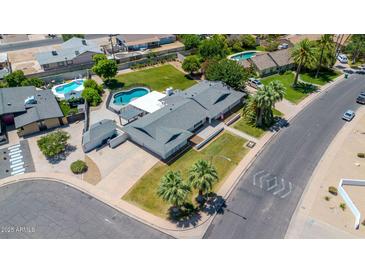 Expansive aerial view of a well-maintained home featuring a pool, lush landscaping, and an inviting outdoor space at 737 E 7Th Pl, Mesa, AZ 85203
