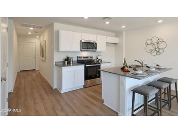 Charming kitchen features stainless steel appliances, granite countertops, and a breakfast bar with stool seating at 1179 N 13Th St, Coolidge, AZ 85128