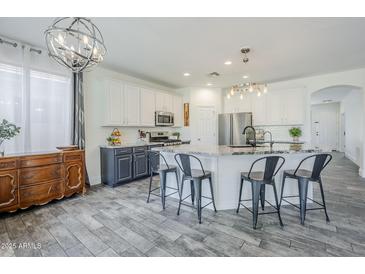 Bright, modern kitchen with white cabinets, stainless steel appliances, and a large center island at 2210 W Calle Del Sol --, Phoenix, AZ 85085