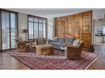 Spacious living room with hardwood floors, a wooden screen, and abundant natural light at 2402 E Esplanade Ln # 1101, Phoenix, AZ 85016
