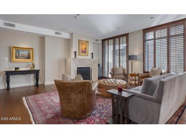 Warm living room with a fireplace, comfortable seating, and a patterned rug at 2402 E Esplanade Ln # 1101, Phoenix, AZ 85016