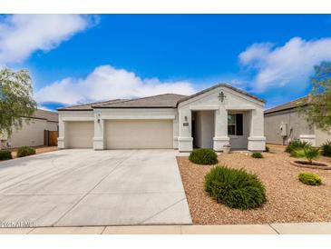 Charming single-story home with a three-car garage and low-maintenance desert landscaping at 3480 N 307Th Dr, Buckeye, AZ 85396
