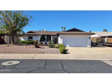 Charming single-story home with a two-car garage, desert landscaping, and a well-maintained lawn at 5002 W Christy Dr, Glendale, AZ 85304