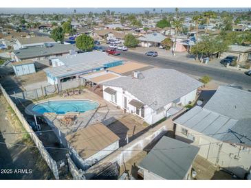 Aerial view of the home showcasing a pool, covered patio, and surrounding neighborhood at 5407 W Cambridge Ave, Phoenix, AZ 85035