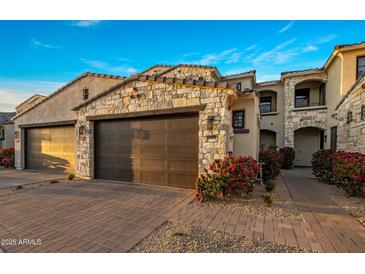 Charming home featuring a stone-accented two-car garage and beautiful landscaping at 6500 E Camelback Rd # 1010, Scottsdale, AZ 85251