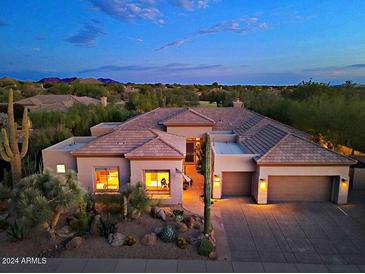 Desert home with a Spanish tile roof, three car garage, and desert landscaping at 6591 E Amber Sun Dr, Scottsdale, AZ 85266