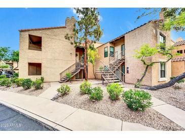 Inviting two-story condo with stairs leading to the front door and well-maintained landscaping at 8787 E Mountain View Rd # 1087, Scottsdale, AZ 85258