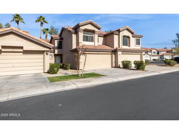 Charming townhome showcasing desert landscaping and a private two-car garage for convenient parking at 1114 W Windjammer Dr, Gilbert, AZ 85233