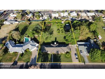 Expansive property with mature trees, a swimming pool, and a charming single-story home outlined with a yellow property line at 125 N Fraser E Dr, Mesa, AZ 85203