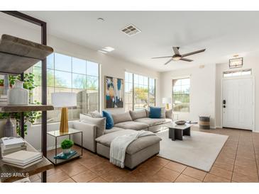 Bright and spacious living room featuring a large sectional sofa and ample natural light at 18414 W La Mirada Dr, Goodyear, AZ 85338